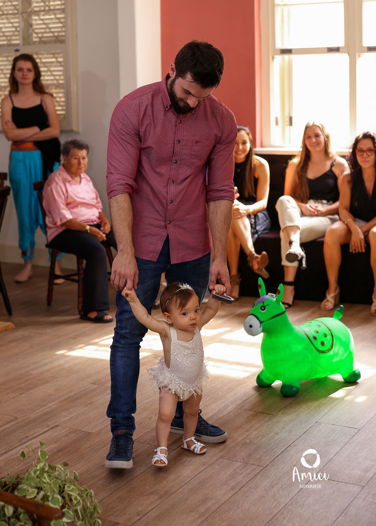 Fotografia de família, bebê caminhando de mãos dadas com o pai.