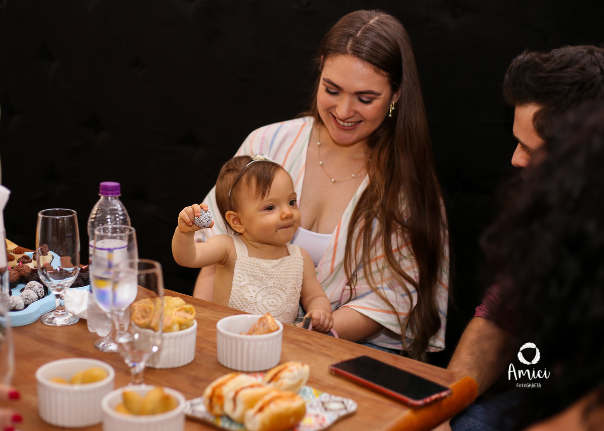 Fotografia infantil, Bebê brincando na mesa enquanto come.