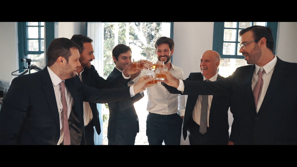FOTOGRAFIA DO NOIVO BRINDANDO COM SEUS PADRINHOS ANTES DA CERIMÔNIA DE CASAMENTO POR HRT FILMES
