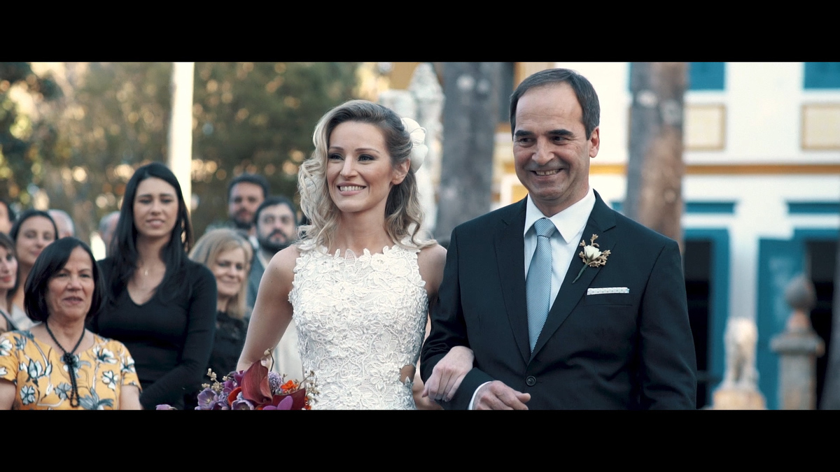 FOTOGRAFIA DA NOIVA ENTRANDO COM SEU PAI NA CERIMÔNIA POR HRT FILMES