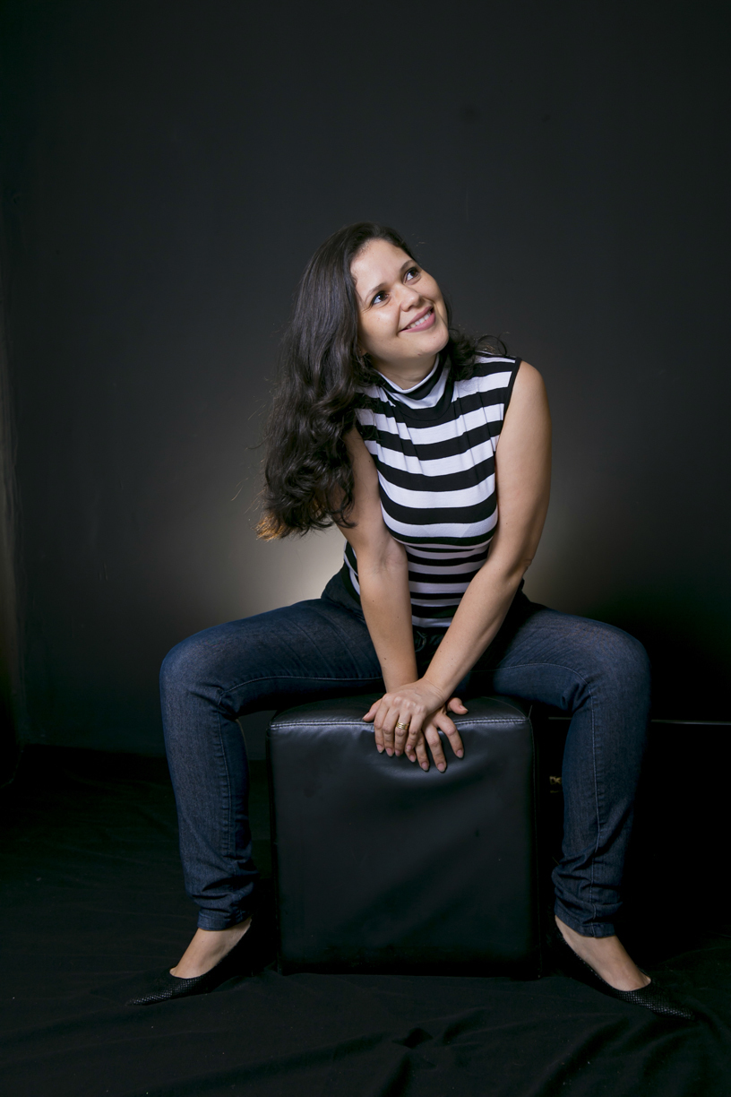 ANGELINA BRUNELO BRUNELO FOTOGRAFIA MÃOS NO PUF E OLHANDO DE LADO 