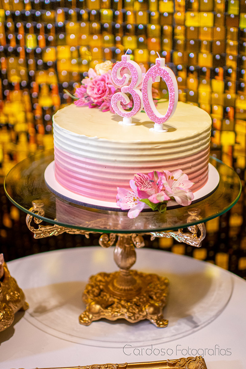 bolo de aniversárioo feminino em tons de rosa e branco, com flores naturais decorando.
