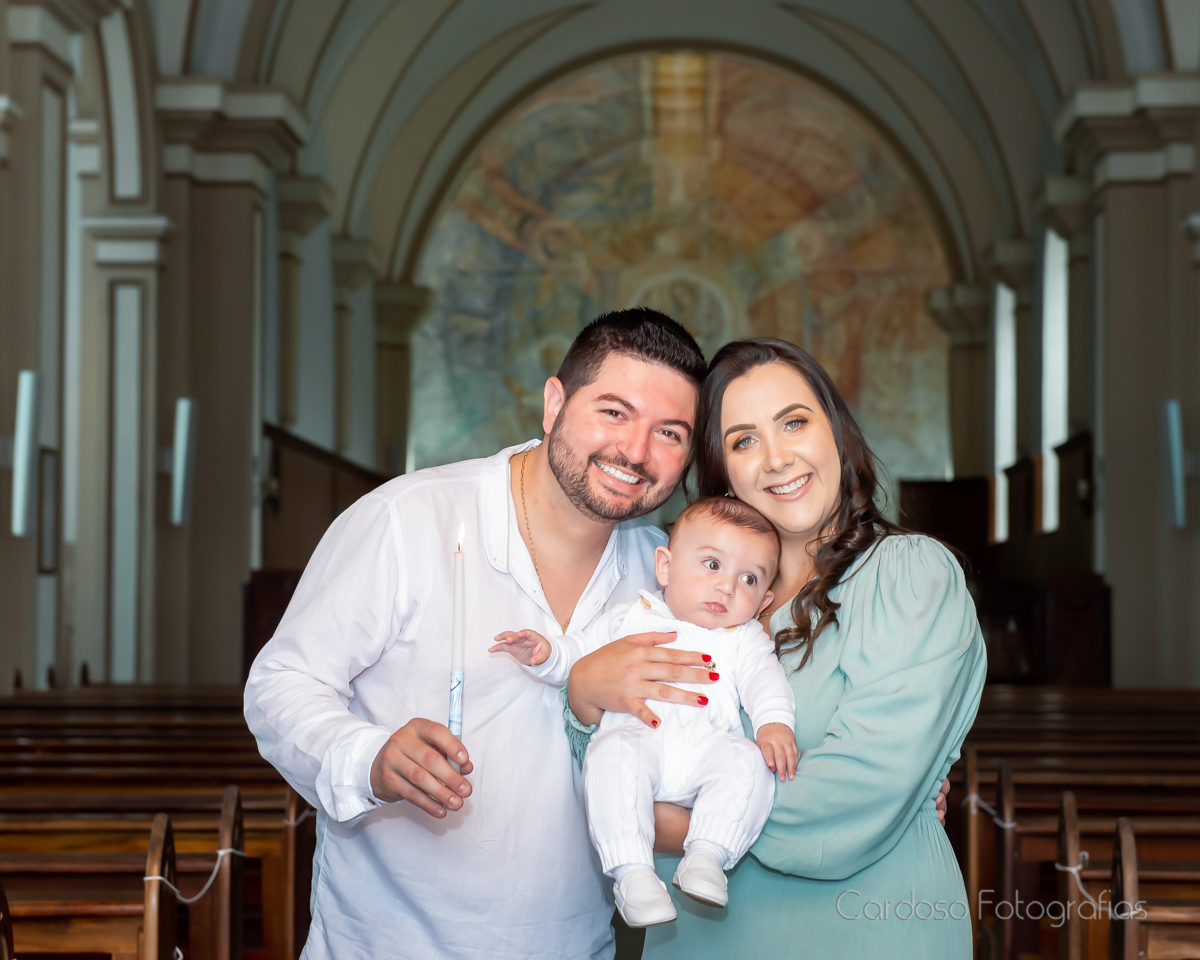 Os pais do bebê batizado em fotografia na frente da igreja.