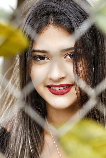 fotografia folhas na cerca com menina