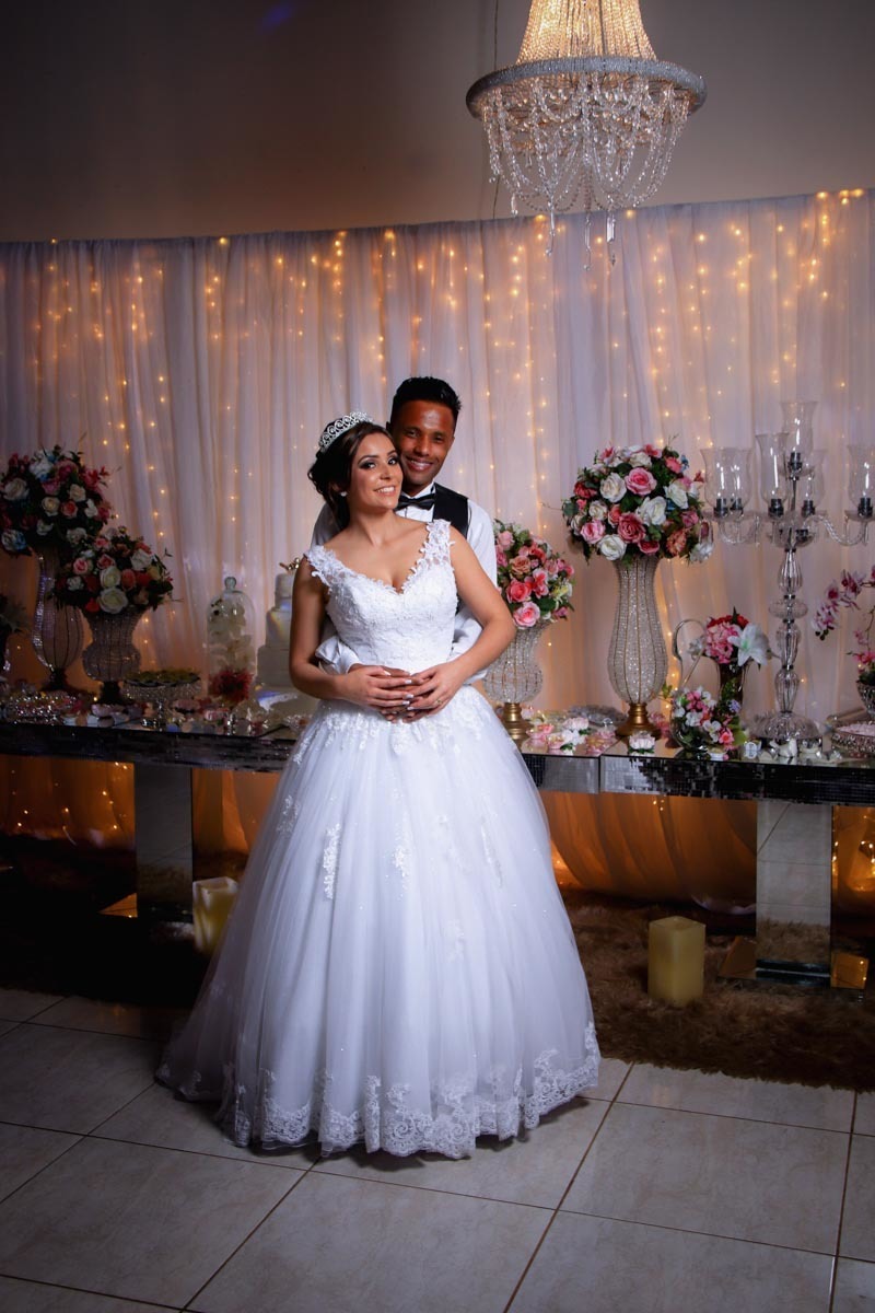 noivos posando na mesa de doces
