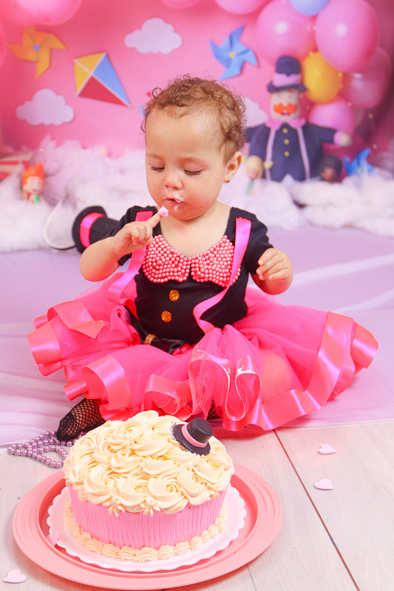 criança colocando dedo no bolo