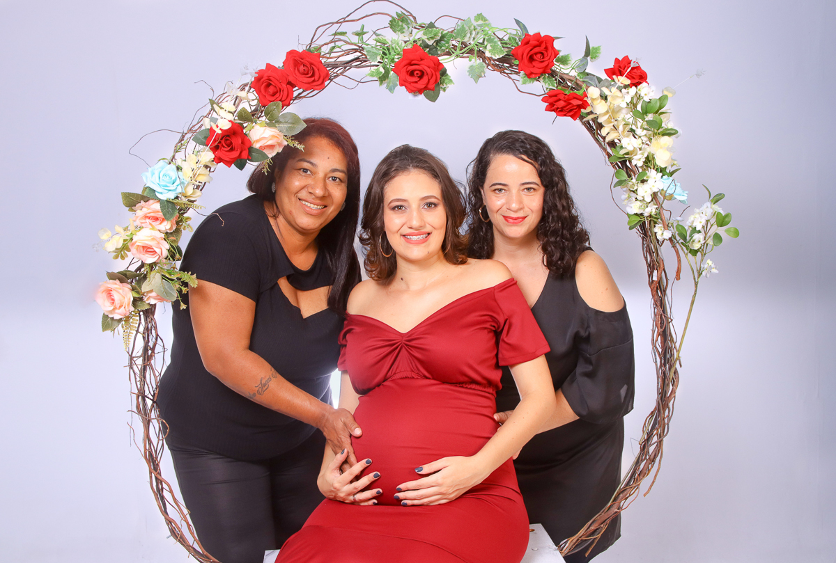gestante com mae e avó no arco de flores