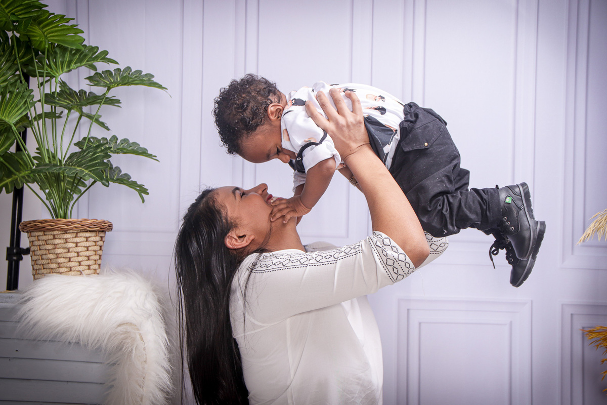 mae segurando o filho acima da cabeca