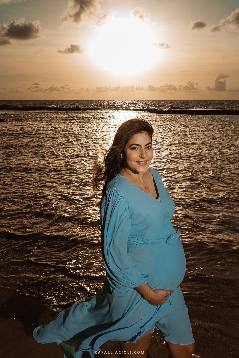 Roberta olha para a câmera com o mar e o sol ao fundo