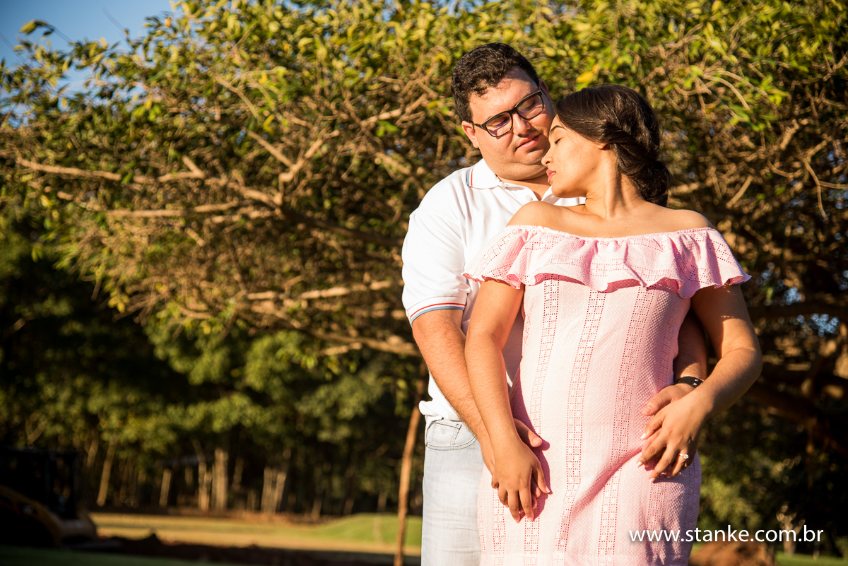 Ensaio no campo. Noivos de frente para sol e noiva encostada no noivo. Fazenda Piana em Sidrolândia-MS.