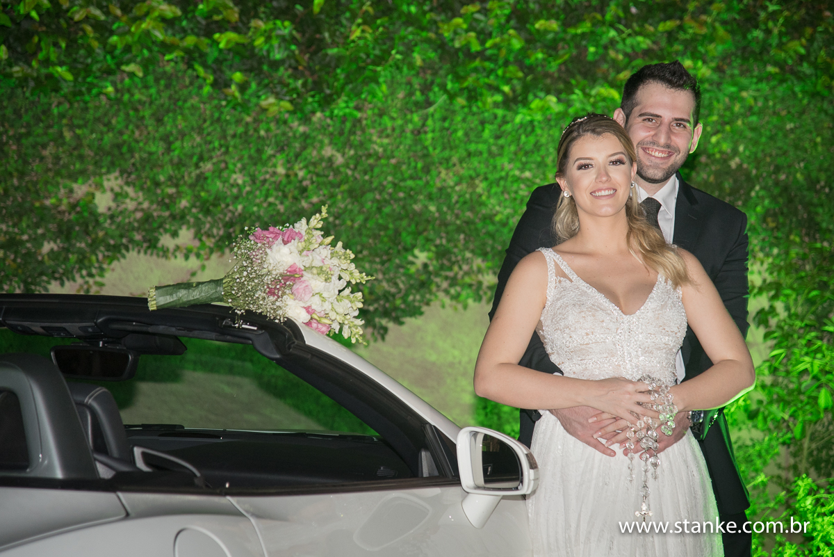 Casamento de Fernanda e Adriano, fotos externas, com abraçados com boque em cima do para brisas, do lado da mercedes, Campo Grande-MS