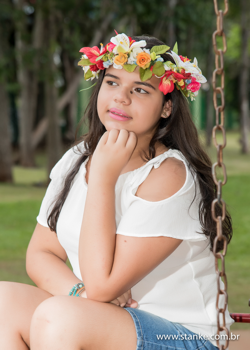 Sofia 15 anos, aniversariante, ensaio externo, sentada no balanço mão no queixo, parque nações indígenas, Campo Grande-ms
