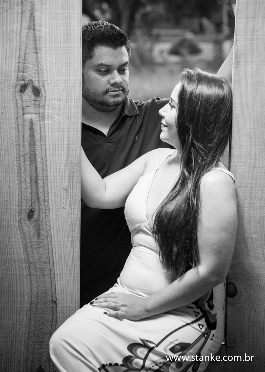 Noivo do lado de fora e noiva sentada na janela, ensaio pré-casamento, de Priscila e Hélio, realizado no Kahala Beach, Campo Grande-MS.