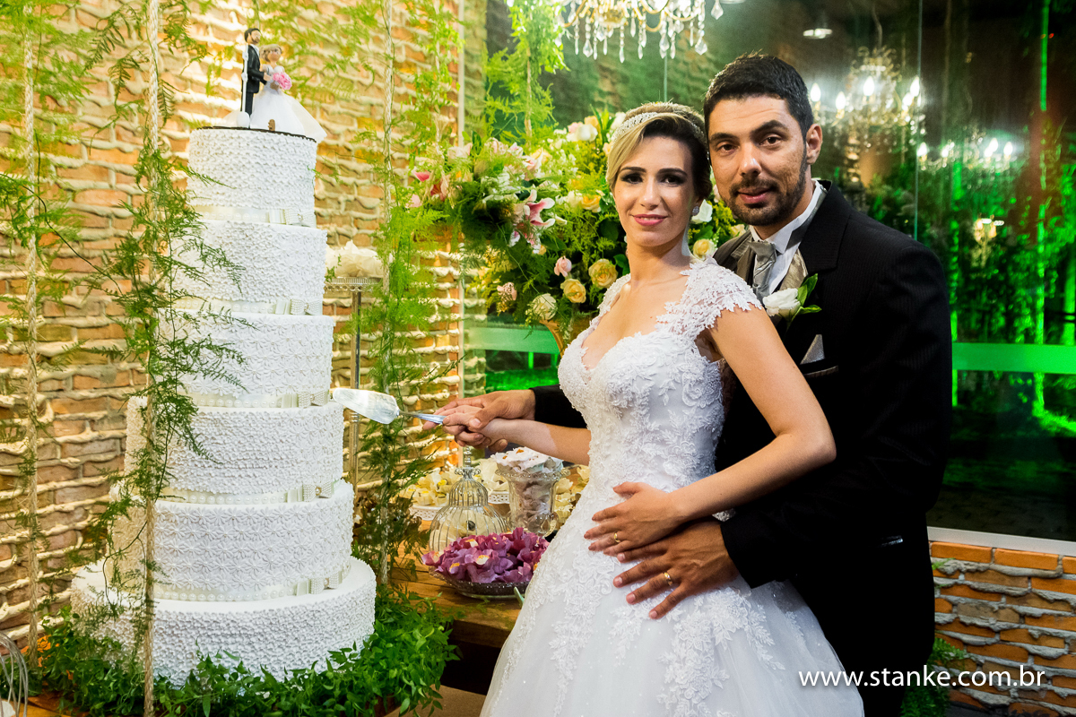 Casamento de Gabriela Sérgio, noivos junto ao bolo, no Open Fest. em Campo Grande-MS