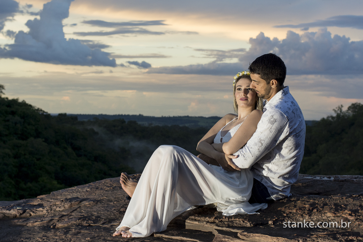 Pre-casamento de Gabi e Sergio, noivos sentados em cina da cachoeira do Rio Negro-MS