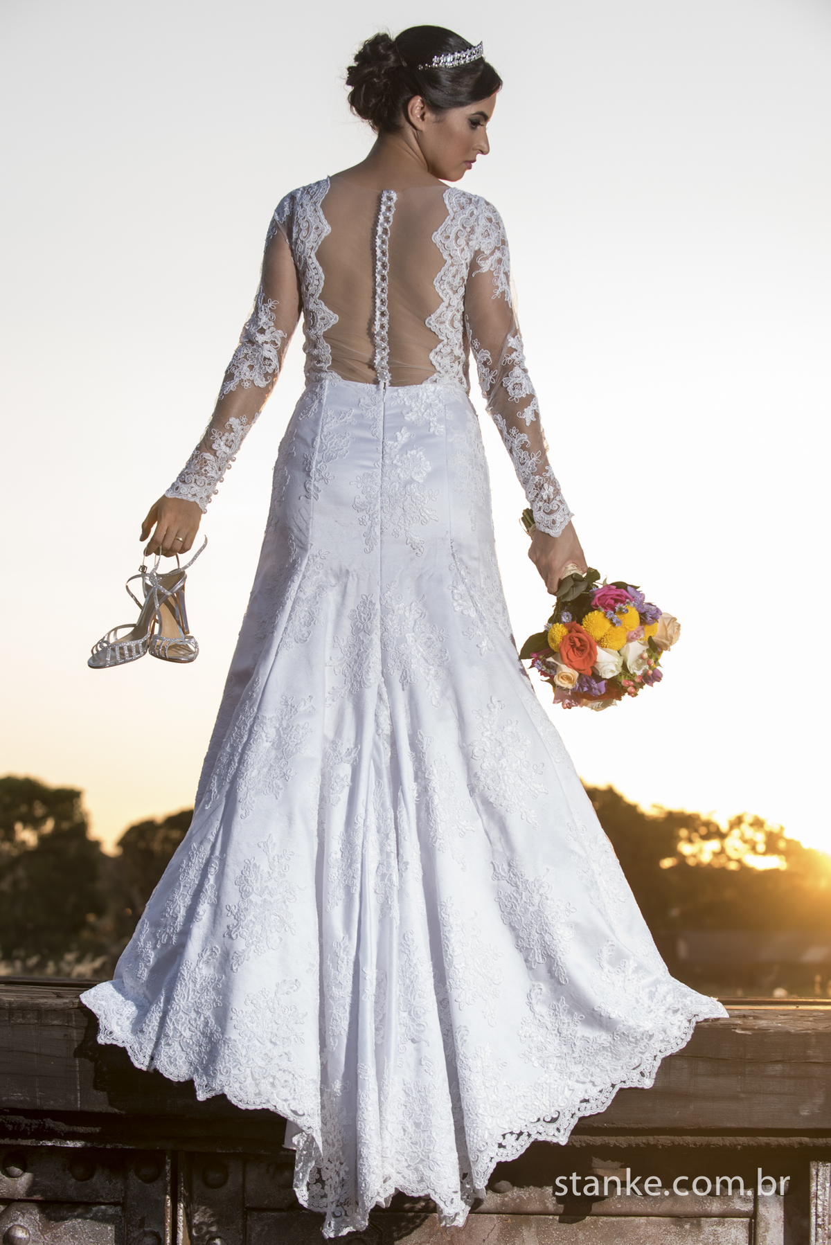 Noiva de costas com sapatos e o buque nas mãos, mostrando os detalhes do vestido. Fotos feita na Rotunda em Campo Grande-MS, Fotos feitas por Pedro Stanke.