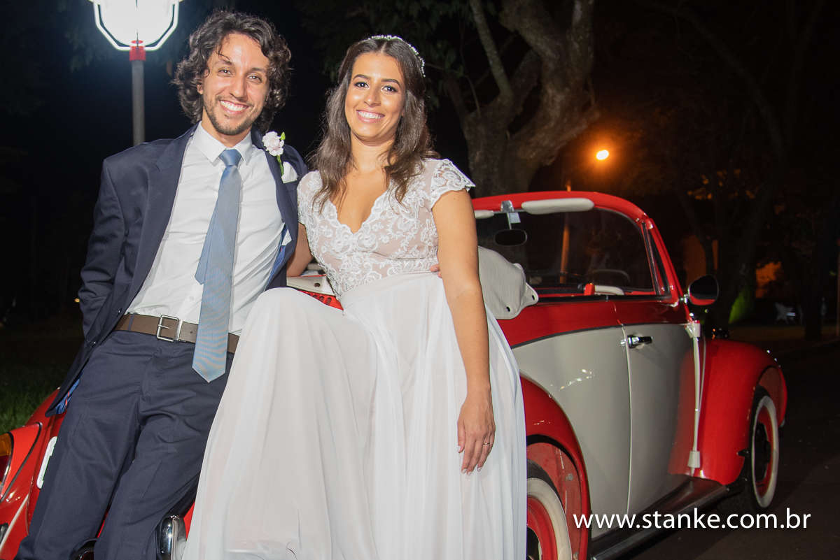 Casamento Raíra e Matheus, os noivos, encostados atrás do fusca charmoso, na Capela Santa Isabel da Hungria, do Hospital do São Julião, Campo Grande-MS, fotos de Pedro Stanke.