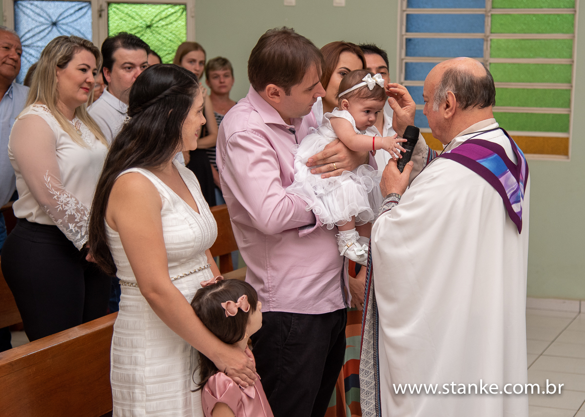 Gabriella no colo do pai recebendo a benção do padre, na Igreja Santíssima Trindade, em Campo Grande-MS. Fotos feitas por Pedro Stanke.