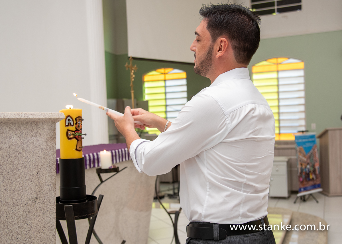 O padrinho da Gabriella acendendo a vela do batismo no Círio Pascal, na Igreja Santíssima Trindade, em Campo Grande-MS. Fotos feitas por Pedro Stanke.