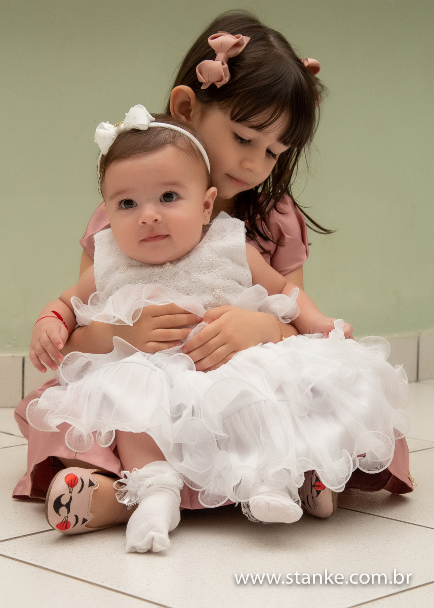 Gabriella sentada no colo de sua irmã, na Igreja Santíssima Trindade, em Campo Grande-MS. Fotos feitas por Pedro Stanke.