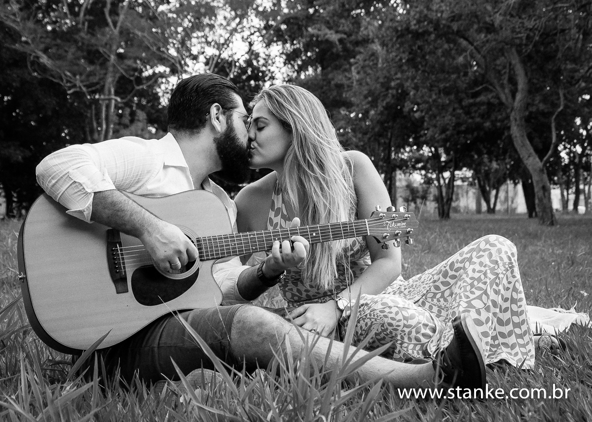 Família Fedrizzi, ensaio externo, Silvio no violão ganhando um beijo da Jennifer. Fotos feitas no Carandá Bosque, Campo Grande, MS, por Pedro Stanke. 