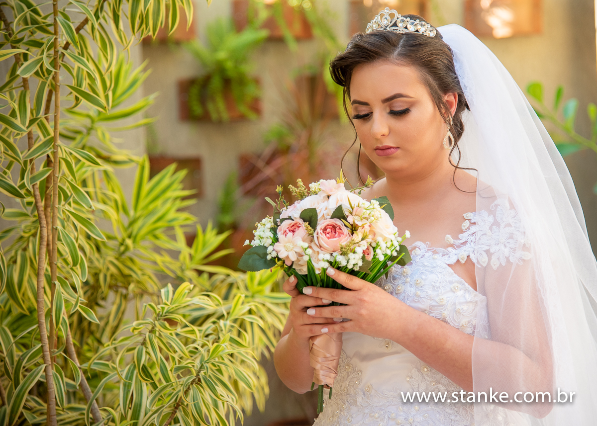 Casamento Mariana e Davi, a noiva Mariana pronta e contemplando o seu buque,  no cantinho de jardim muito lindo. Fotos feitas no Espaço Manar. Fotos feitas por Pedro Stanke.