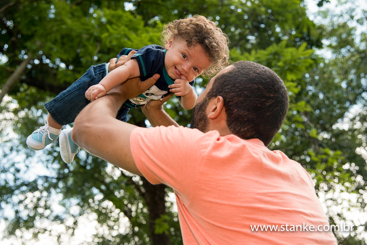 Artur com lindo sorriso quando o seu pai levante ele nos braços e bem alto. Fotos feitas em Campo Grande-MS, pelo Fotógrafo Pedro Stanke.e