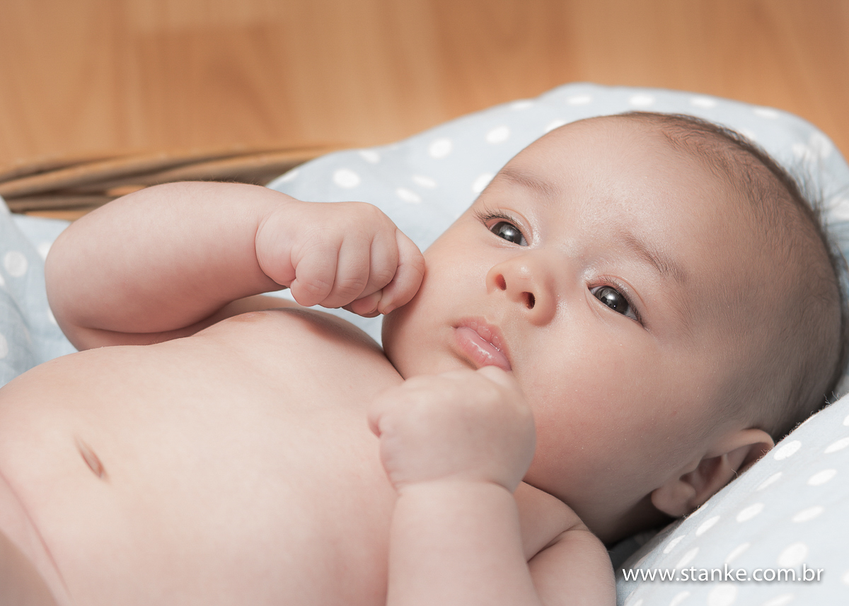 Newborn do Isaque com 28 dias. Isaque dentro da cesta com as mãozinhas no rosto. Fotos feitas em Campo Grande-MS, pelo Fotógrafo Pedro Stanke.