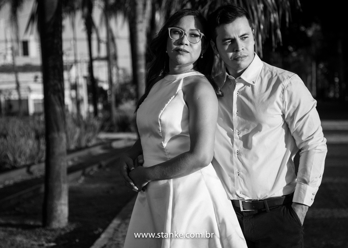 Ensaio pós casamento de Giseli e Aurélio, Foto Preto e Branco. A Giseli encostada de costas no Aurélio e ele com umas das mãos no bolso, e ambos para mesma direção para frente. Fotos feitas no Memorial Ferroviário, em Campo Grande-MS, por Pedro Stanke.