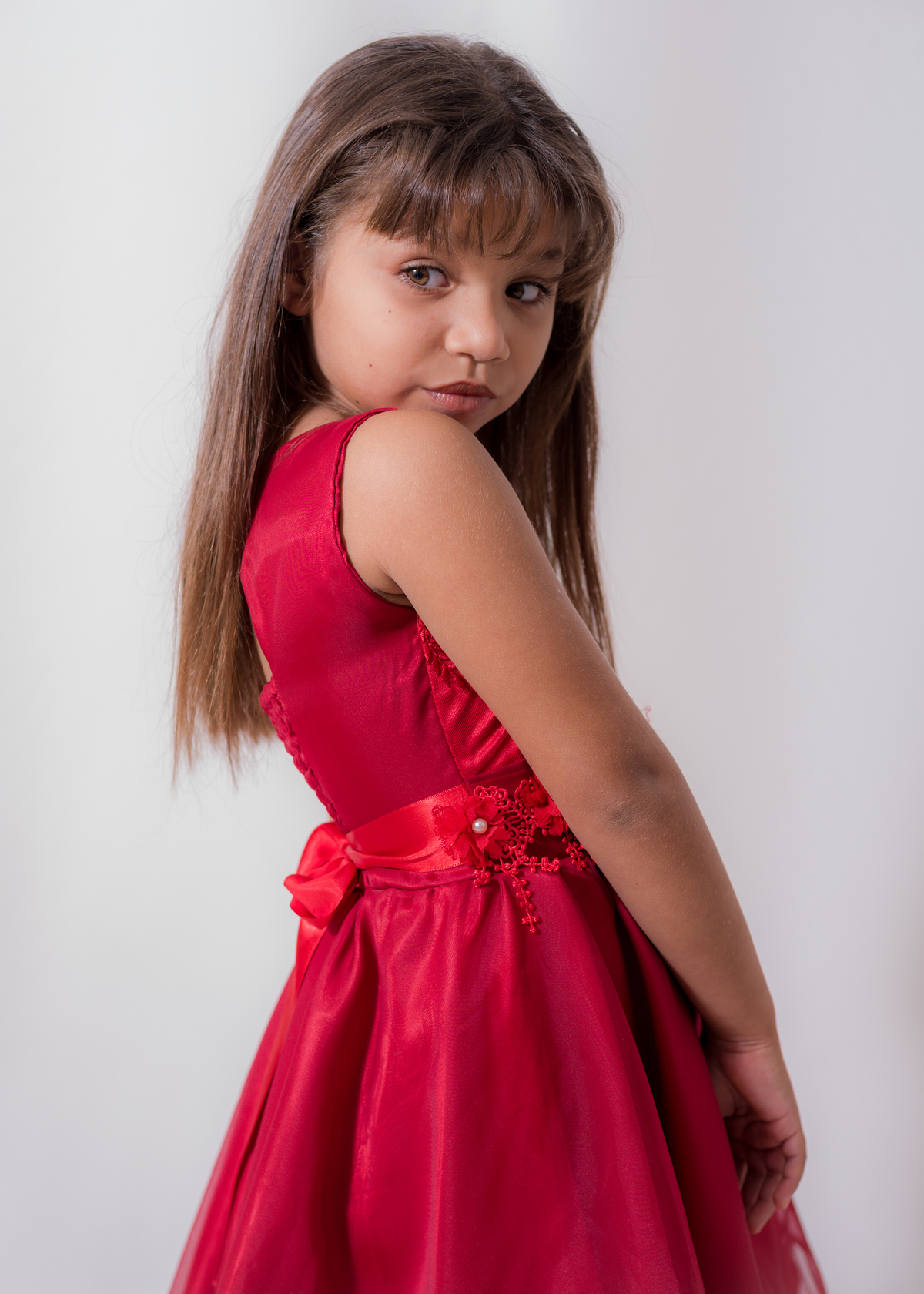 Ensaio em estúdio da Júlia 09 anos, posando de lado, e olhando sobre o ombro e braço rente ao corpo. Fotos feitas em Campo Grande-MS, pelo fotógrafo Pedro Stanke.