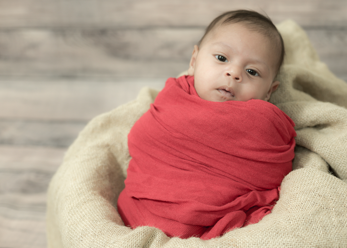 Ensaio do João com seus 30 dias, enroladinho em tecido vermelho e super antenado a tudo o que acontecia. Fotos feitas por Pedro Stanke, em Campo Grande-MS.