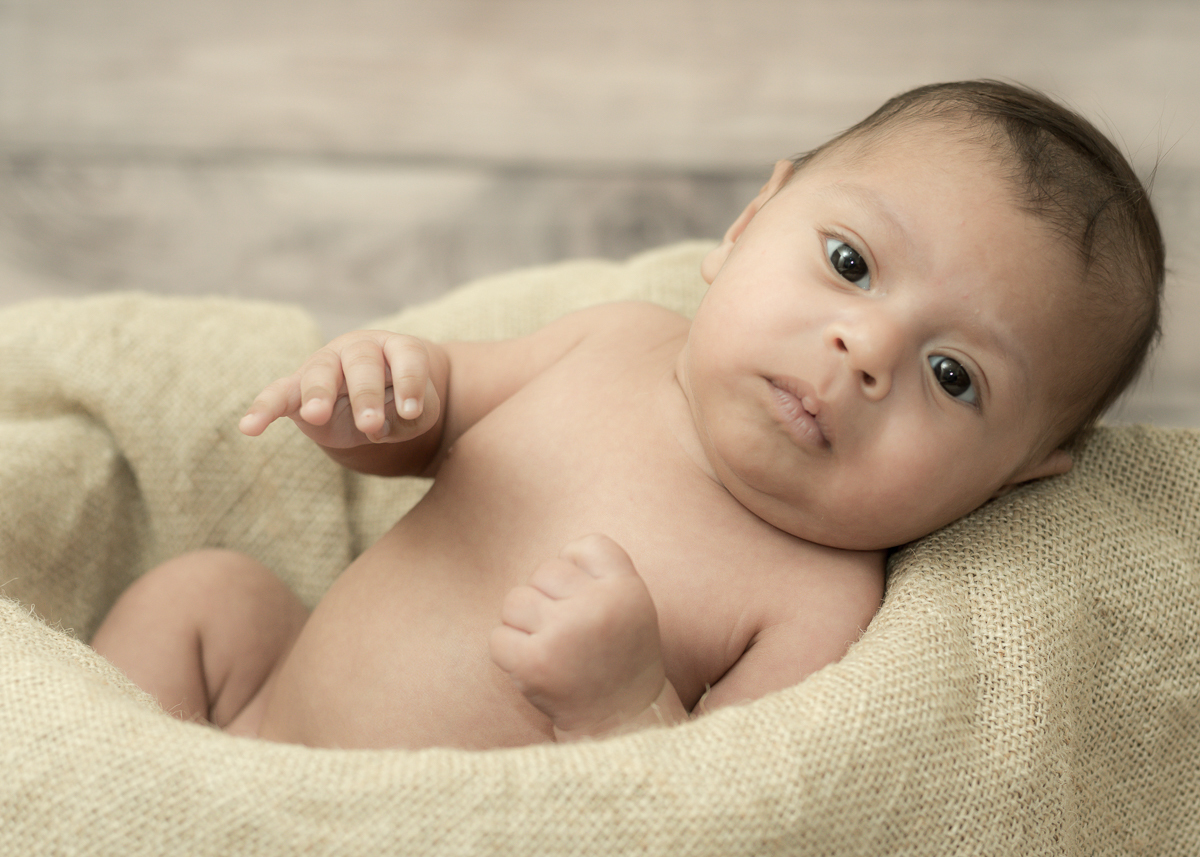 Ensaio do João com seus 30 dias, meio que sentadinho dentro um balde com estopa macia e olhando para câmera. Fotos feitas por Pedro Stanke, em Campo Grande-MS.