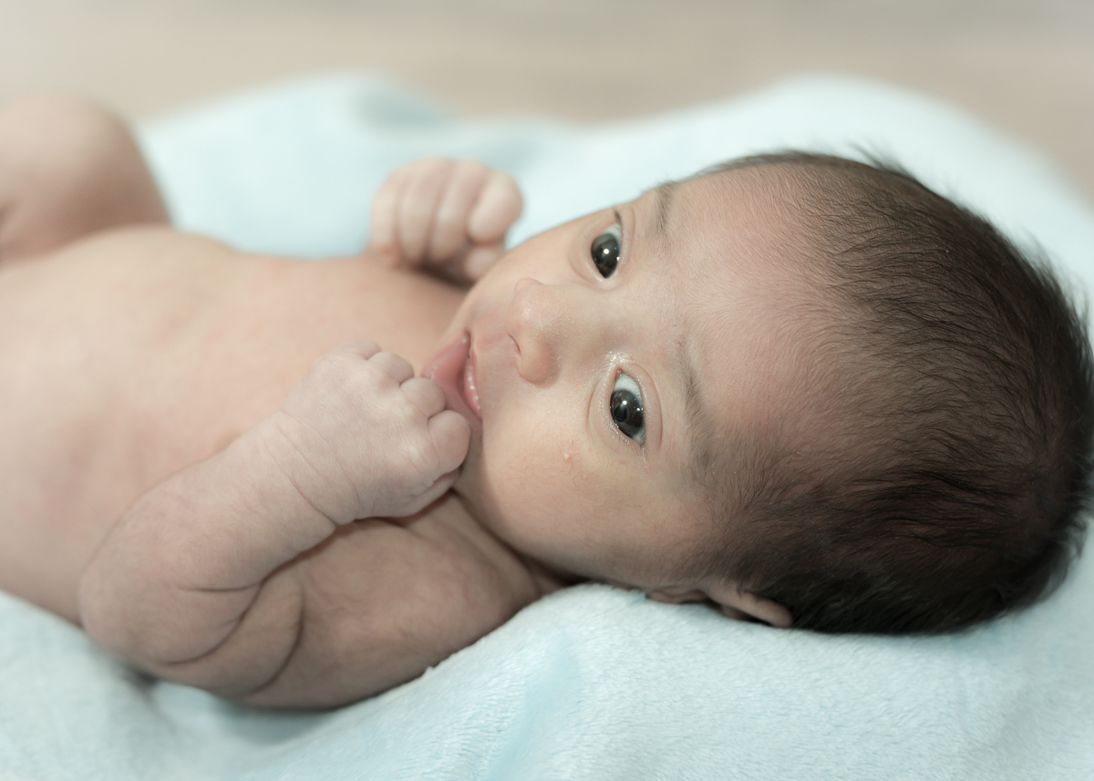 Ensaio Heitor, 27 dias. Super acordado e deitadinho em sua manta que ganhou da sua vovó, com a mãozinha na boca. Fotos feitas pelo fotógrafo Pedro Stanke, em Campo Grande-MS.