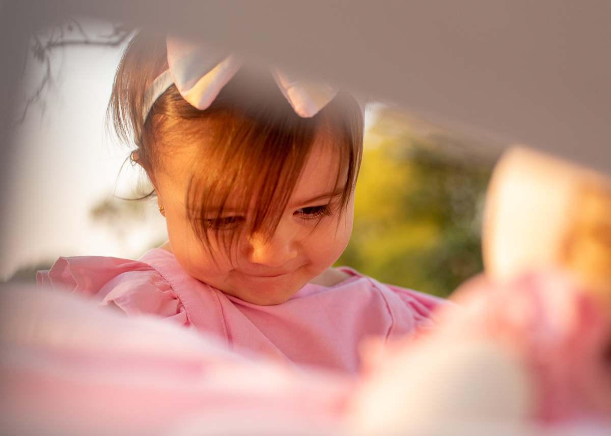 Smash the Cake da Gabriella, Um close da Gabi, através do encosto do banco, e o sol iluminado o seu rosto e refletindo nas árvores. Fotos feitas pelo fotógrafo Pedro Stanke em Campo Grande-MS. 