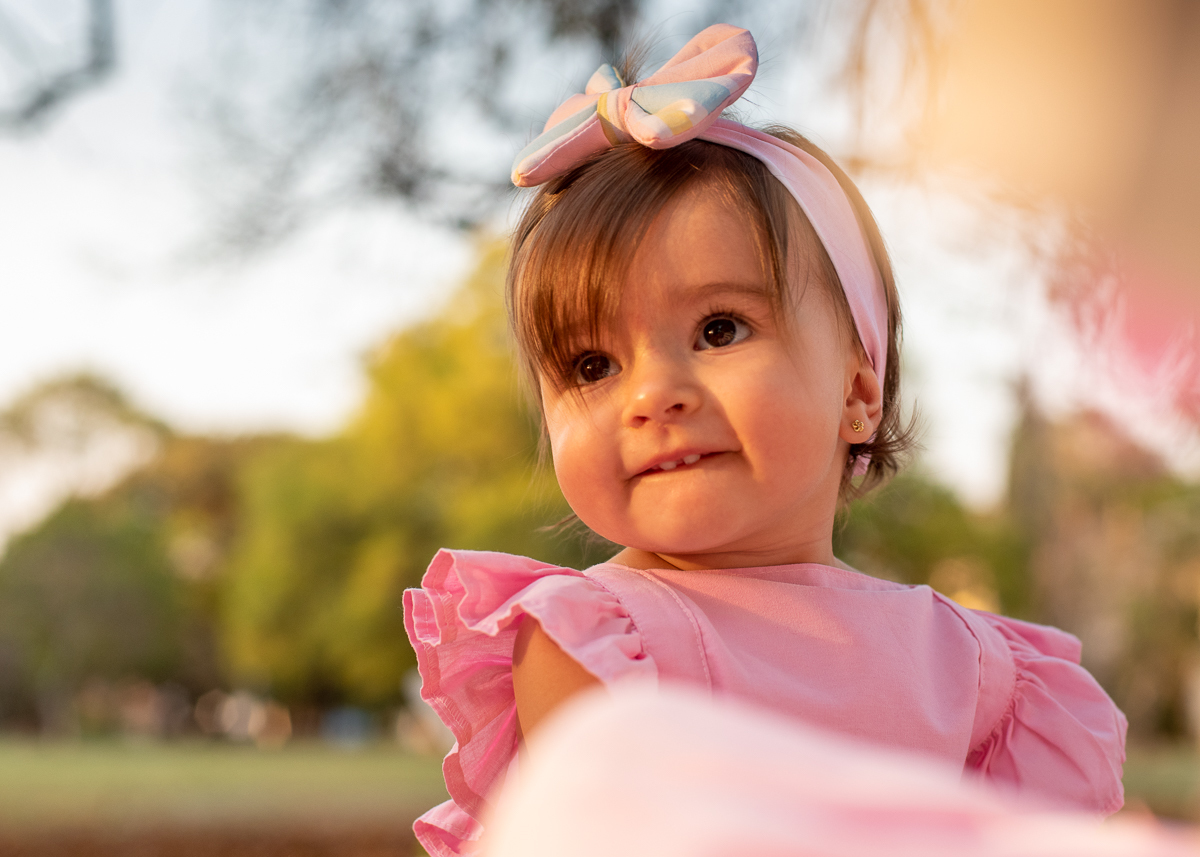 Smash the Cake da Gabriella, Um close da Gabi, olhando de lado e o sol iluminado o seu rosto e refletindo nas árvores. Fotos feitas pelo fotógrafo Pedro Stanke em Campo Grande-MS. 