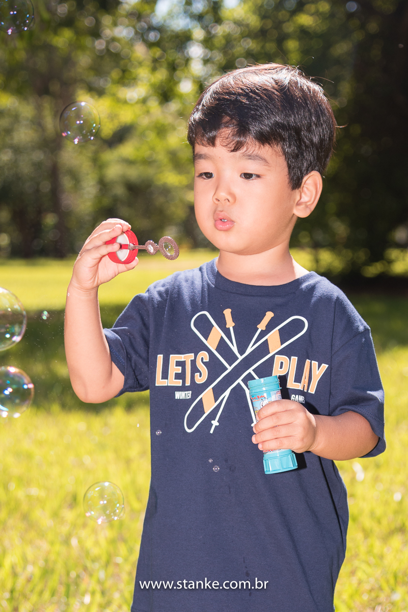 Ensaio infantil do Davi com 4 anos, Aniversariante, fazendo soprando para fazer as bolhinhas de sabão. Fotos feitas no Bosque da Paz, pelo fotógrafo Pedro Stanke. 