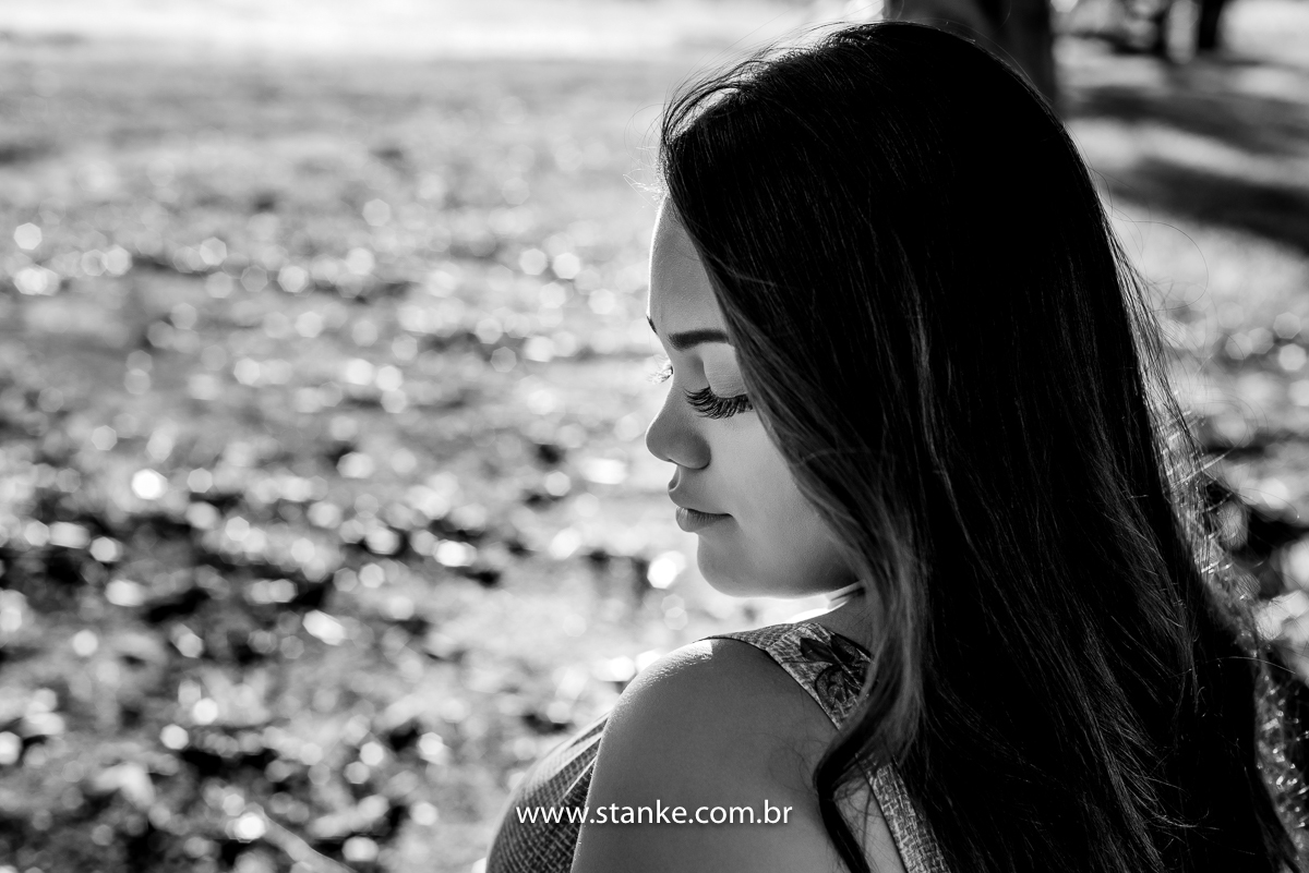 Ensaio 15 anos externo, uma foto preto e branco, da aniversariante com olhar abaixado e de lado, e sentada. Fotos realizadas Estância Mariana perto Campo Grande-MS. Fotógrafo Pedro Stanke.