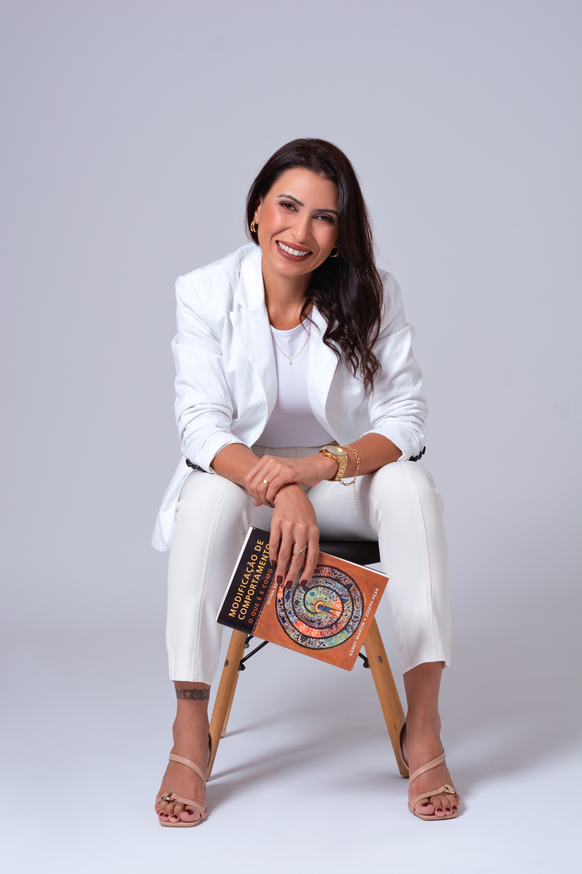 Sentada sorrindo com um livro de psicologia