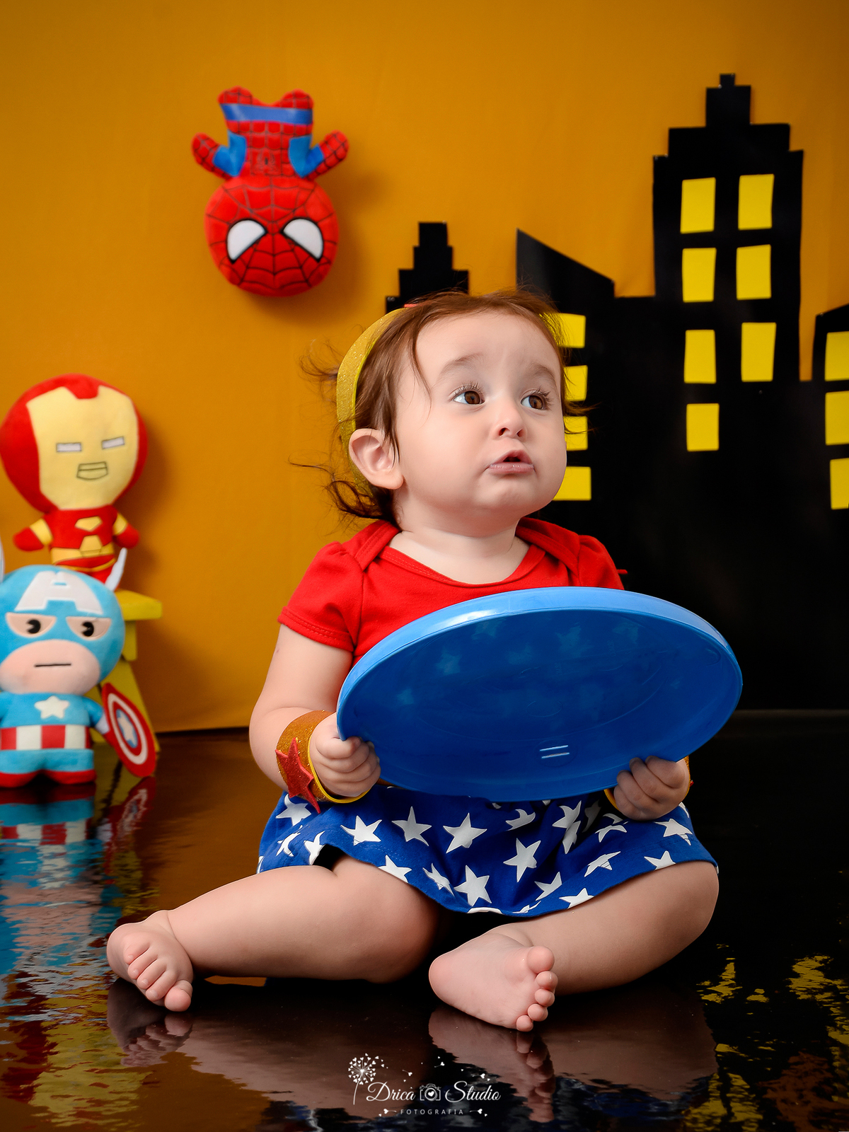 Drica Studio Fotografias - Drica Studio - Xinguara Pará - Acompanhamento Mensal - ensaio menina com escudo do capitão américa - prédio - Flash - roupa mulher maravilha    