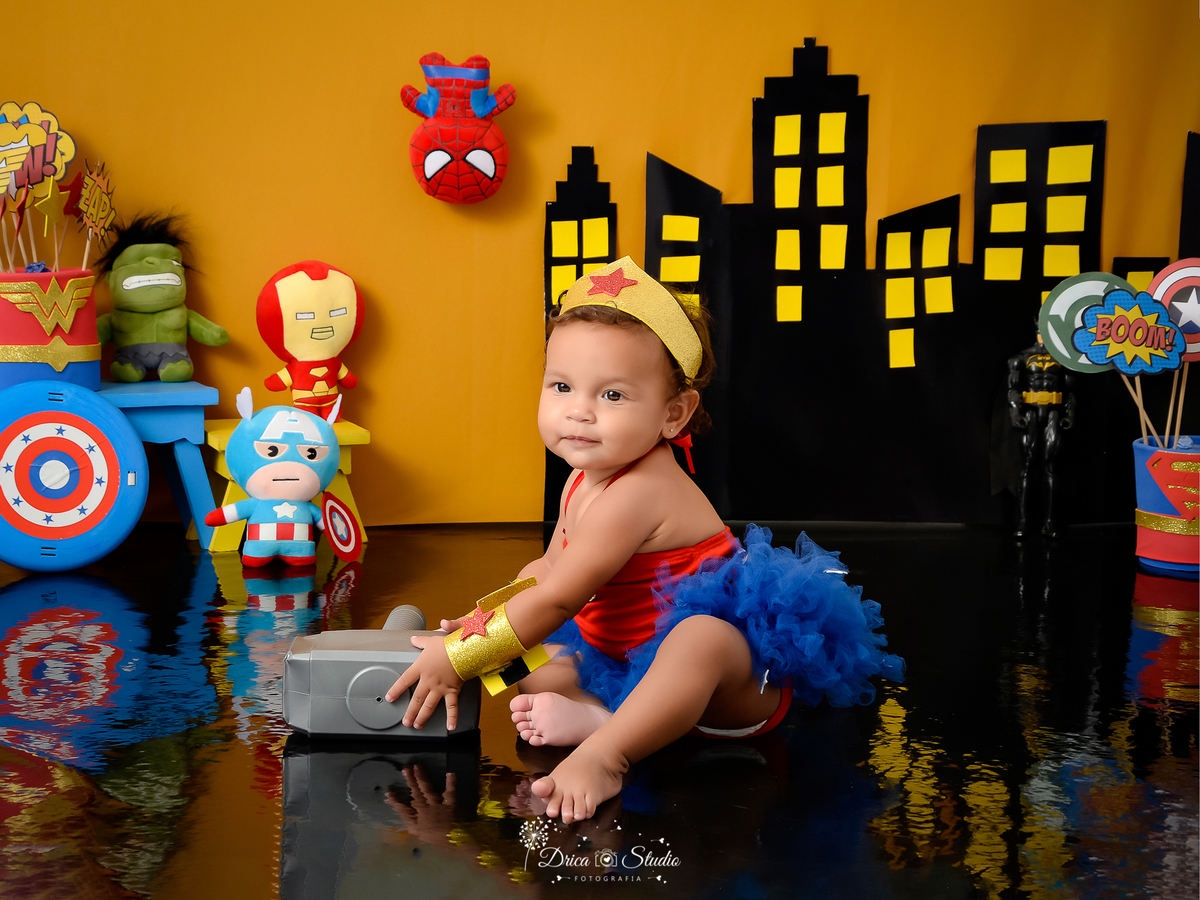 Drica Studio Fotografias - Drica Studio - Xinguara Pará - Acompanhamento Mensal - ensaio de menina - cenário super herói - vestido - mulher maravilha - martelo - escudo 