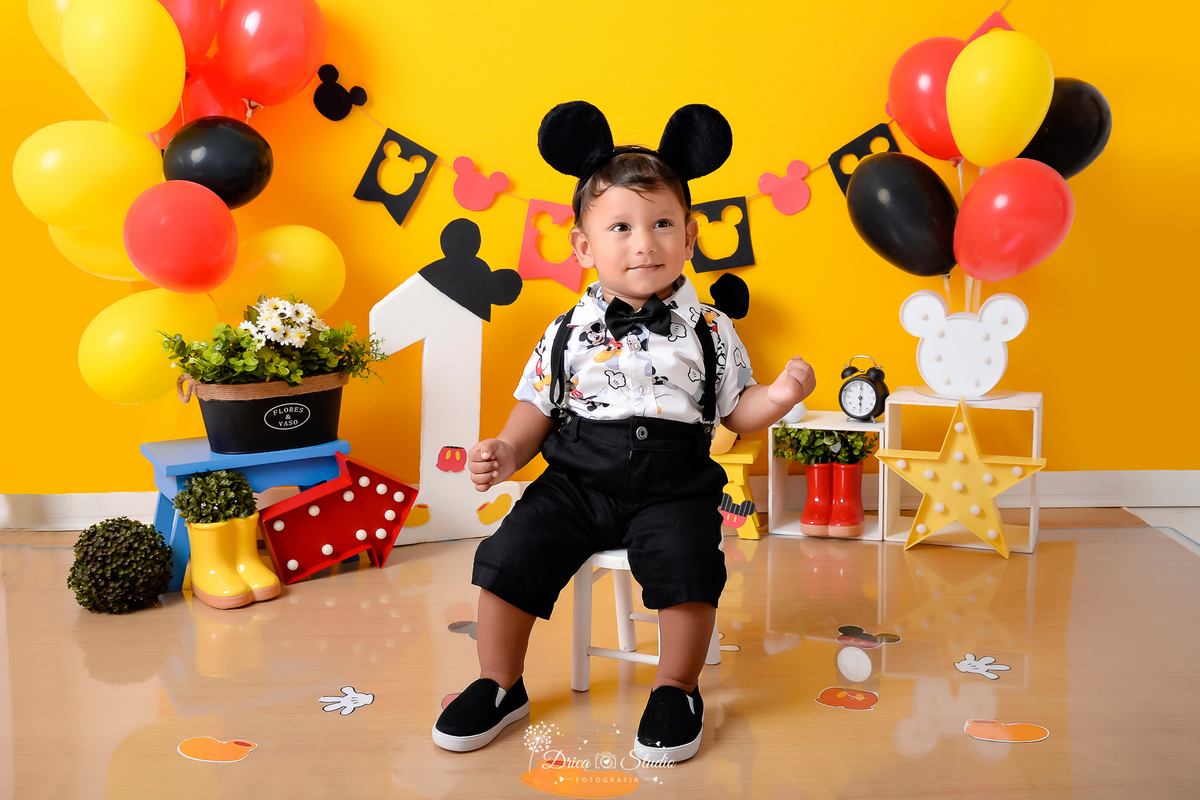 Drica Studio - Drica Studio Fotografias - Drica Studio Xinguara Pará - book infantil - Smash the Cake - Mickey Mouse - cenário com o bolo - urso do Mickey - número 1 - roupa do Mickey - orelha - balões coloridos - amarelo - vermelho - preto 