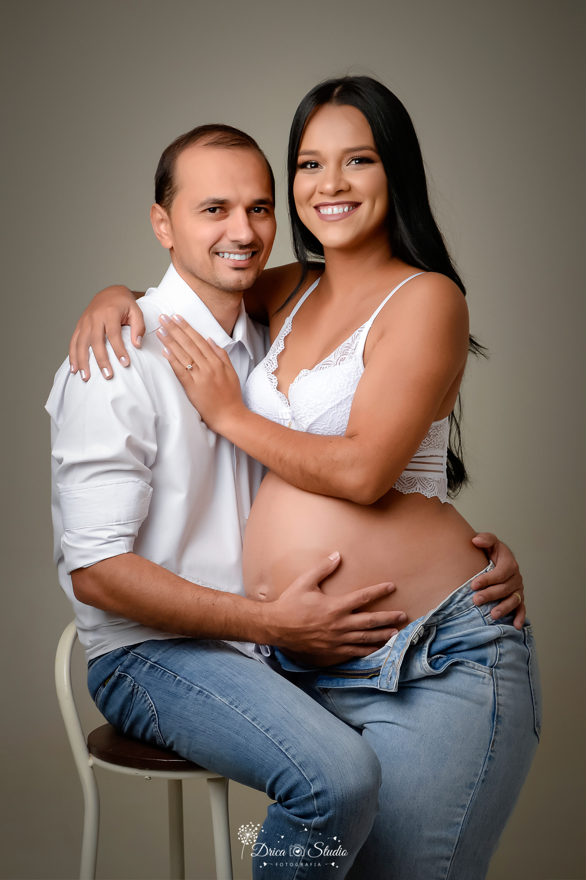 Drica Studio - Drica Studio Fotografias - Drica Studio Xinguara Pará - fotos de gestante - gravidinha - casal - sentado na cadeira - calça jeans - camisa branca - sutiã branco - abraçados - fotos clean  