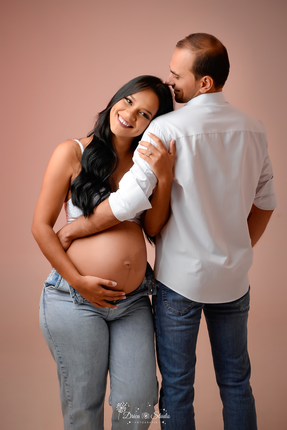 Drica Studio - Drica Studio Fotografias - Drica Studio Xinguara Pará - fotos de gestante - gravidinha - casal - calça jeans - camisa branca - sutiã branco - abraçados - fotos clean - encostada no ombro 