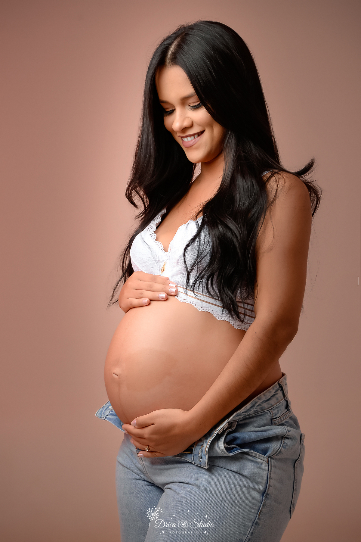 Drica Studio - Drica Studio Fotografias - Drica Studio Xinguara Pará - fotos de gestante - ensaio feminino - Studio - gestante Fashion - ensaio de gestante fundo claro - pegando na barriga - calça jeans - sutiã branco 