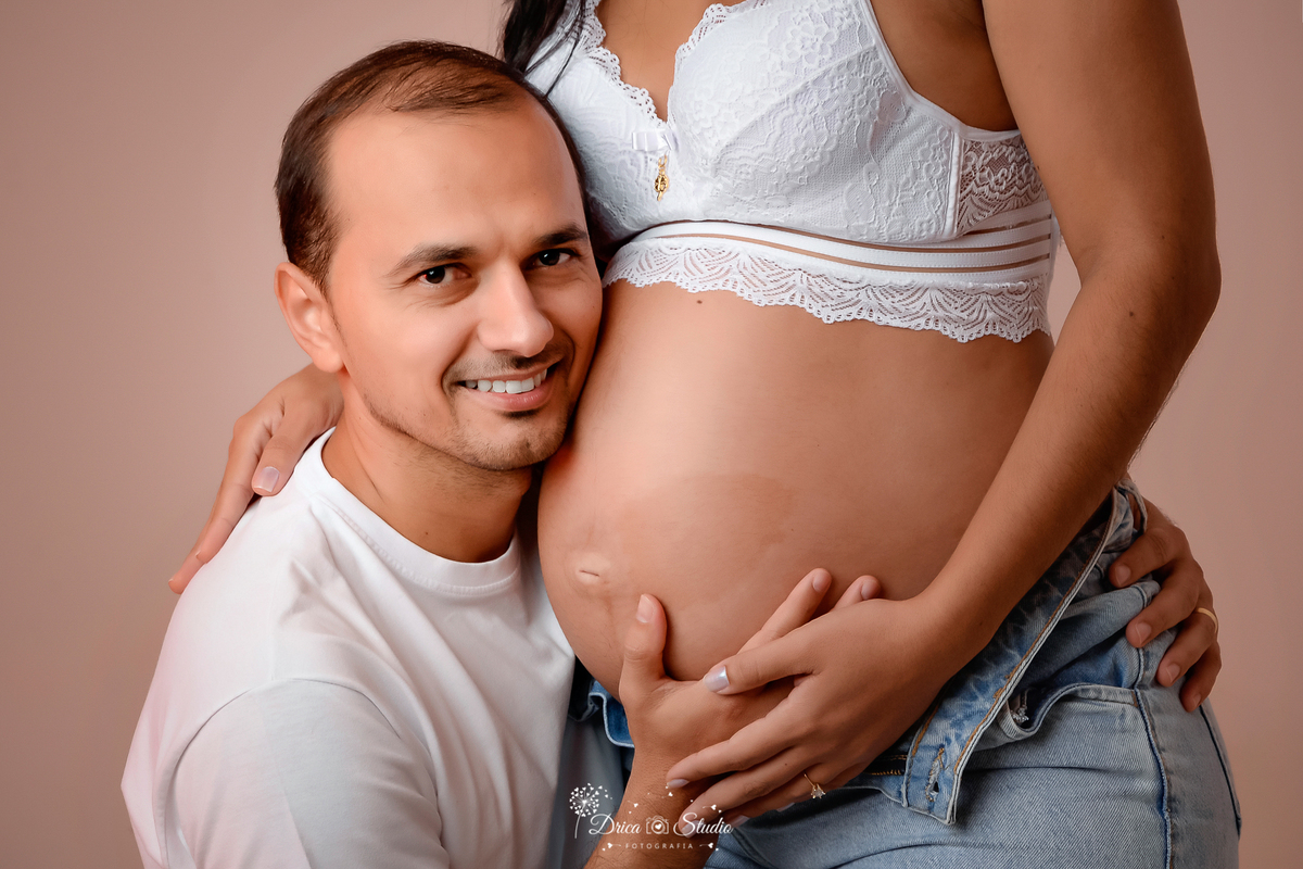 Drica Studio - Drica Studio Fotografias - Drica Studio Xinguara Pará - ensaio de gravida - marido e mulher - roupas composta em tons mais claros - branco - calça jeans - mão na barriga - olhando um para o outro - encostado na barriga 
