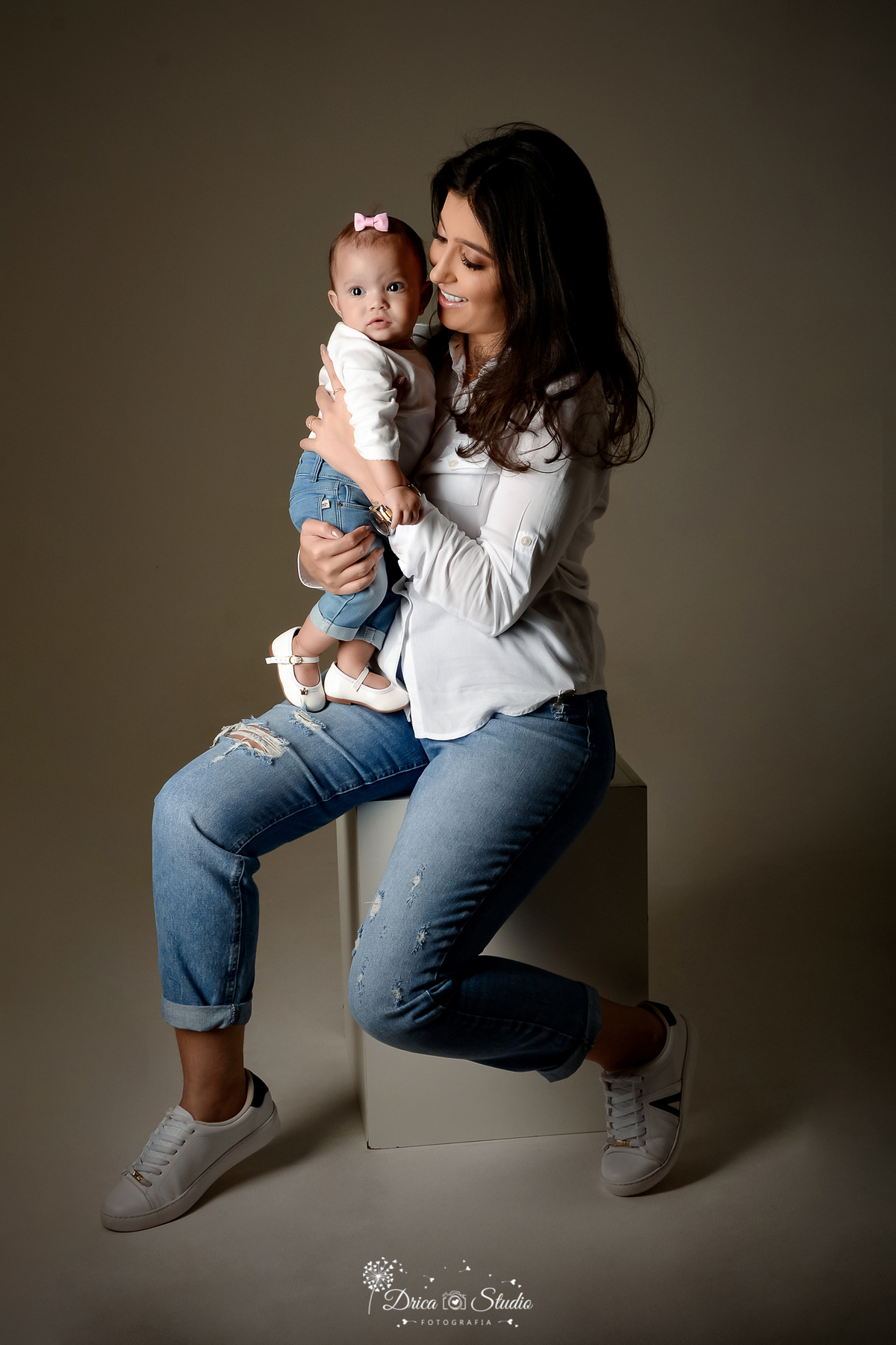 Drica Studio - Drica Studio Fotografias - Xinguara Pará - ensaio mãe e filha - Studio - Clean - roupas tons claros - brancas - calças jeans - fundo cinza - alegres - brincando - sapato branco - mãe de menina 