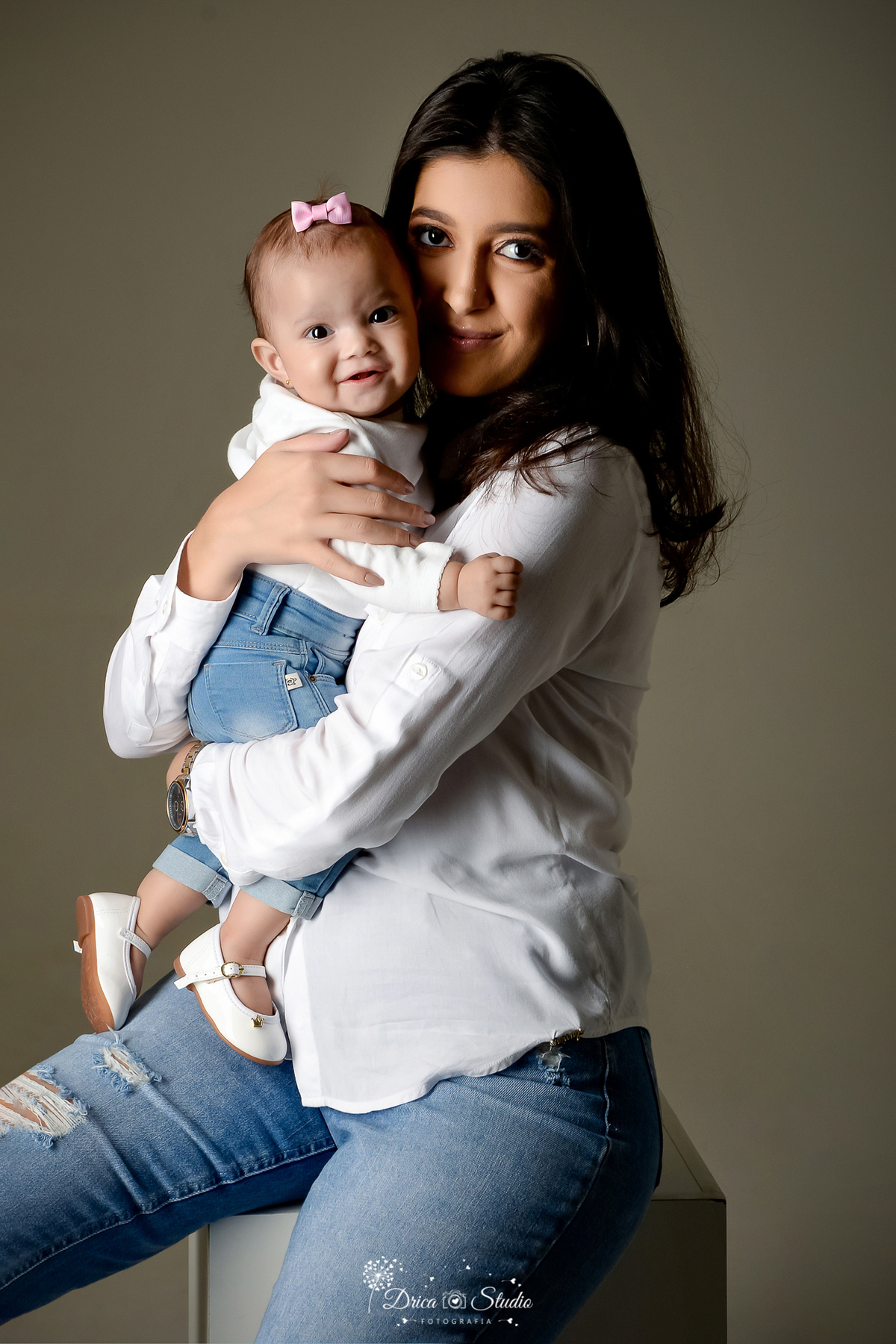 Drica Studio - Drica Studio Fotografias - Xinguara Pará - ensaio mãe e filha - Studio - Clean - roupas tons claros - brancas - calças jeans - fundo cinza - no colo - brincando - sapato branco - mãe de menina