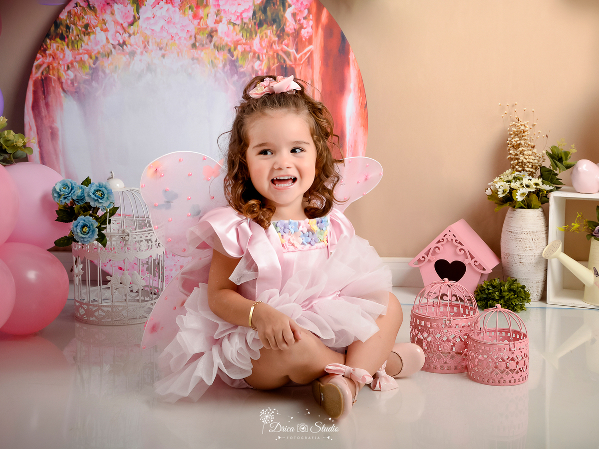 ensaio-infantil-fotografico-criança-3-aninhos studio-fotografico-em-xinguara-pará-fotógrafa-em-xinguara-menina-cenário-fada-jardim-encantado-figurino-rosa-acessórios-foto-aniversário