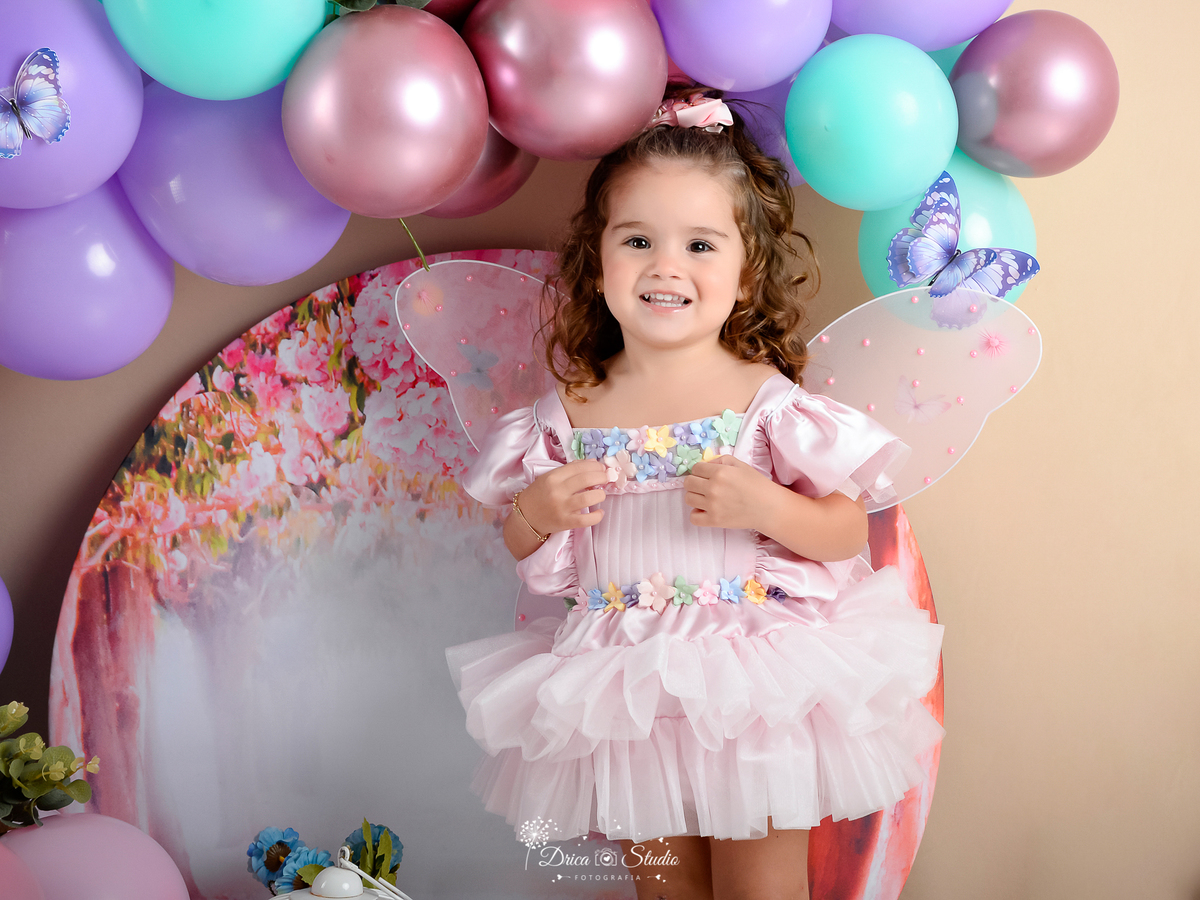 ensaio-infantil-fotografico-criança-3-aninhos studio-fotografico-em-xinguara-pará-fotógrafa-em-xinguara-menina-cenário-fada-jardim-encantado-figurino-rosa-acessórios-foto-aniversário