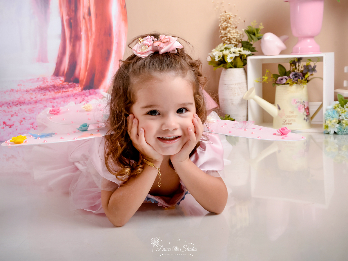 ensaio-infantil-fotografico-criança-3-aninhos studio-fotografico-em-xinguara-pará-fotógrafa-em-xinguara-menina-cenário-fada-jardim-encantado-figurino-rosa-acessórios-foto-aniversário